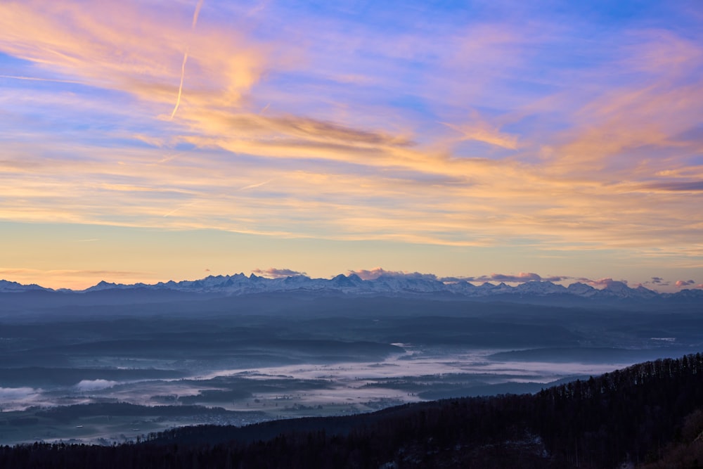 a view of a mountain range with clouds in the sky