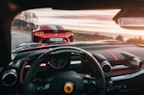 A vibrant red sports car with custom steering wheel visible through the window.