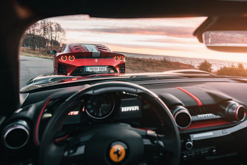 A vibrant red sports car with custom steering wheel visible through the window.
