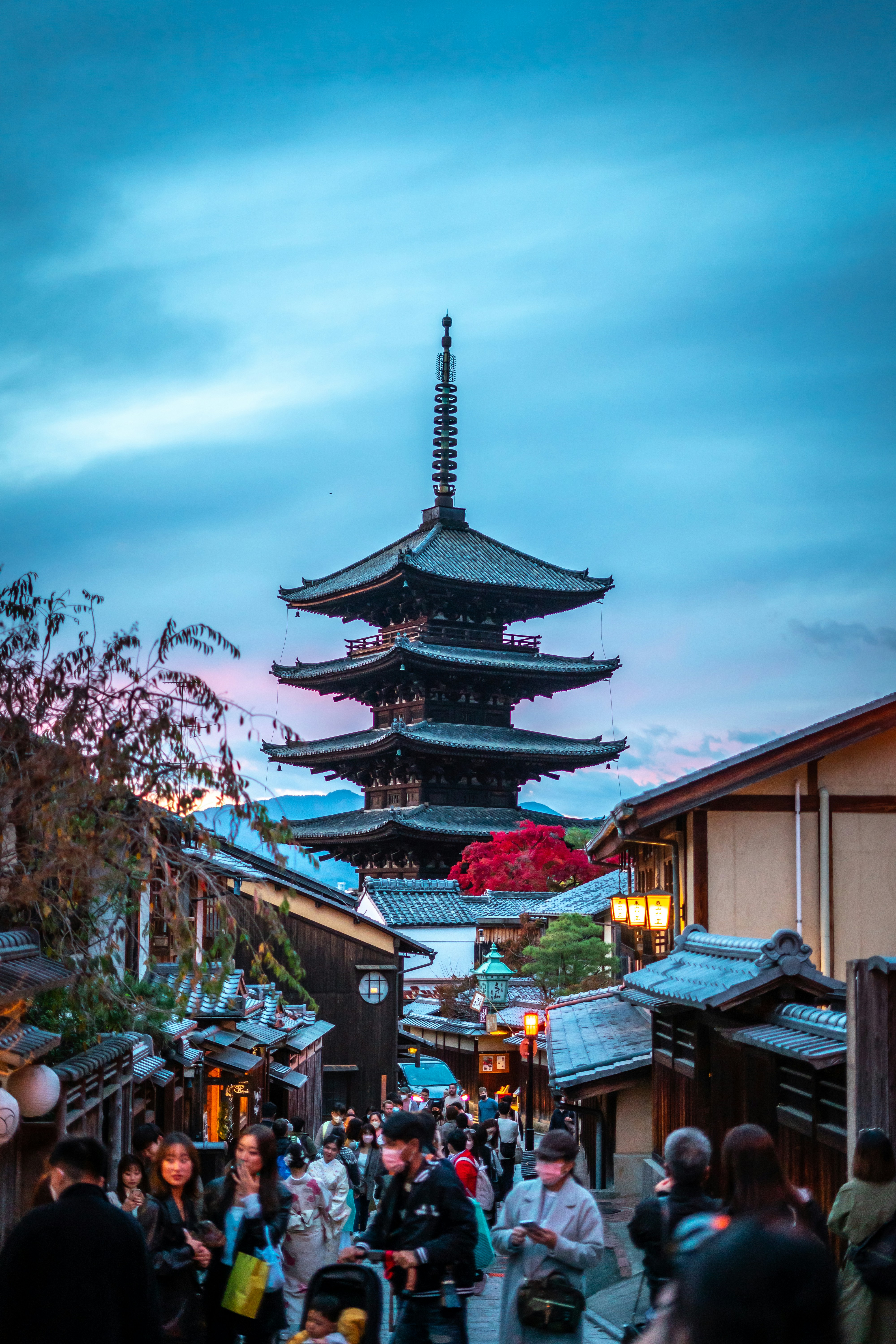 Un grupo de personas caminando por una calle junto a edificios altos