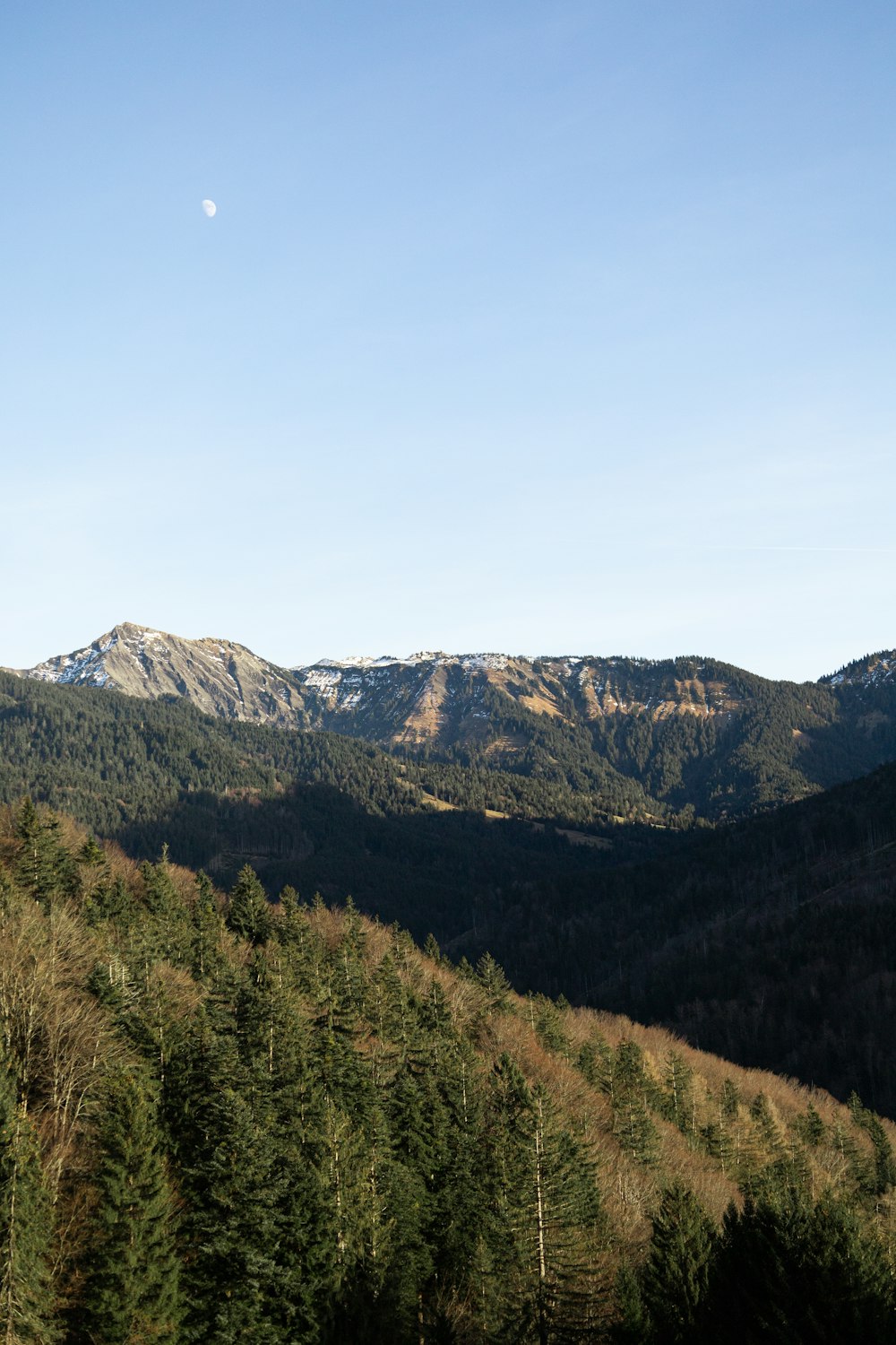 a view of a mountain range with a full moon in the distance