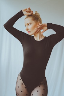 a woman in a black bodysuit posing for a picture