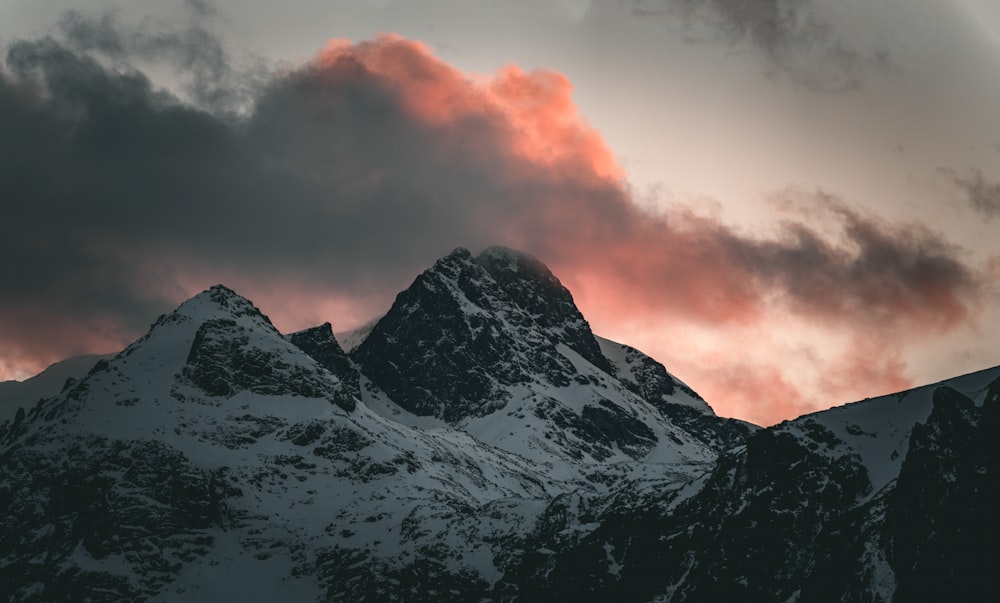 a snow covered mountain under a cloudy sky