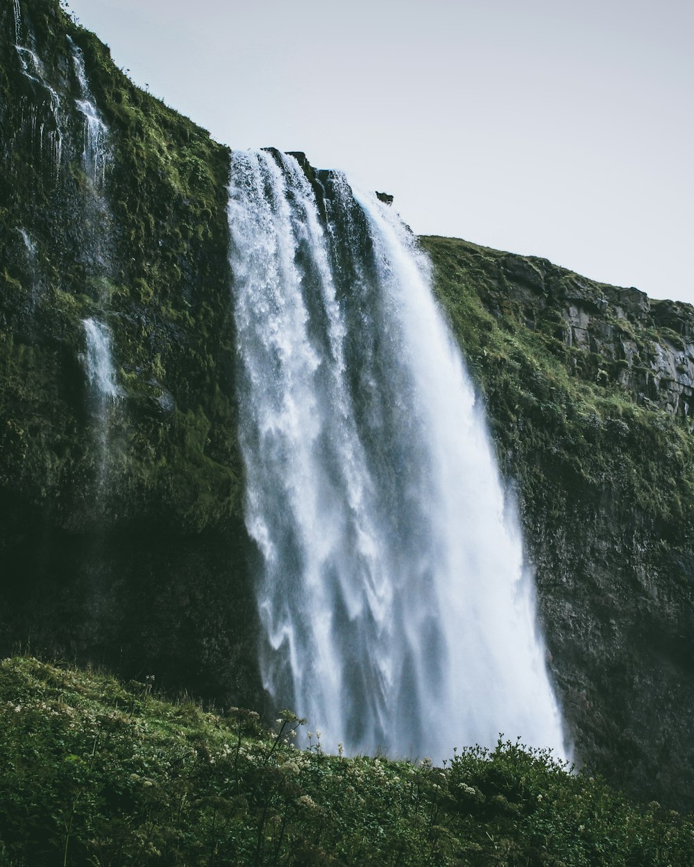 a tall waterfall with water cascading down it's side