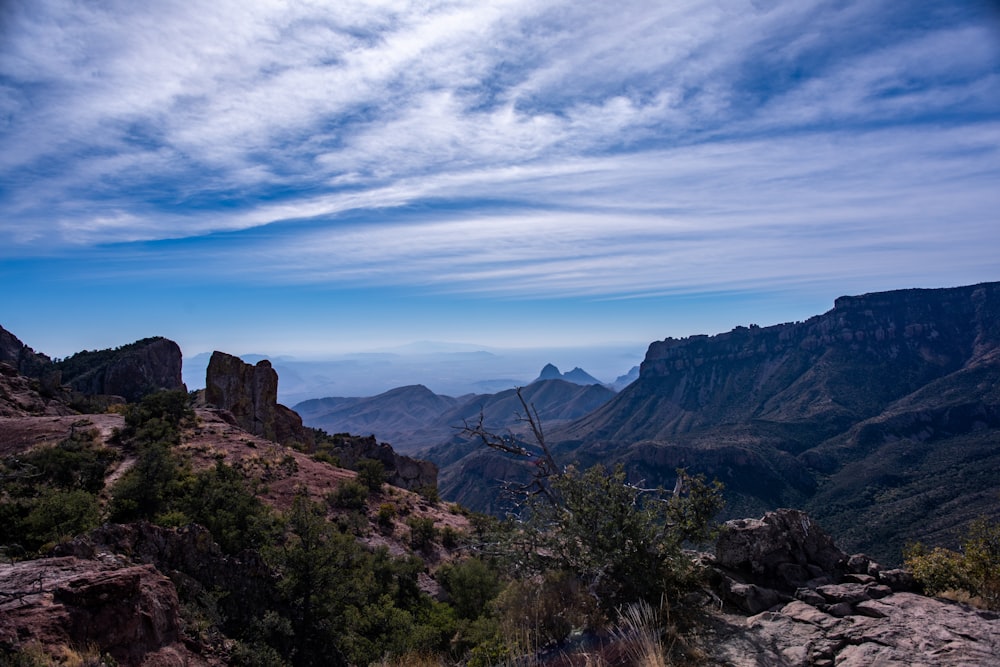 a view of a mountain range from the top of a hill