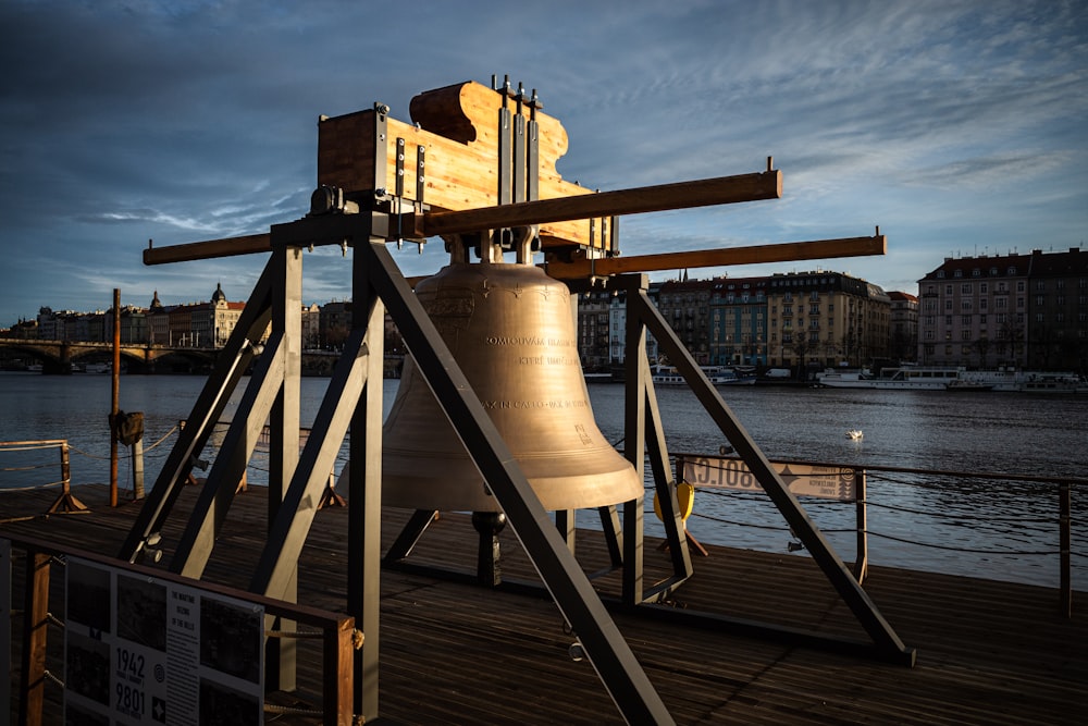a large bell sitting on top of a wooden pier