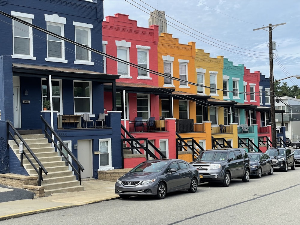 a row of multi - colored houses on a city street