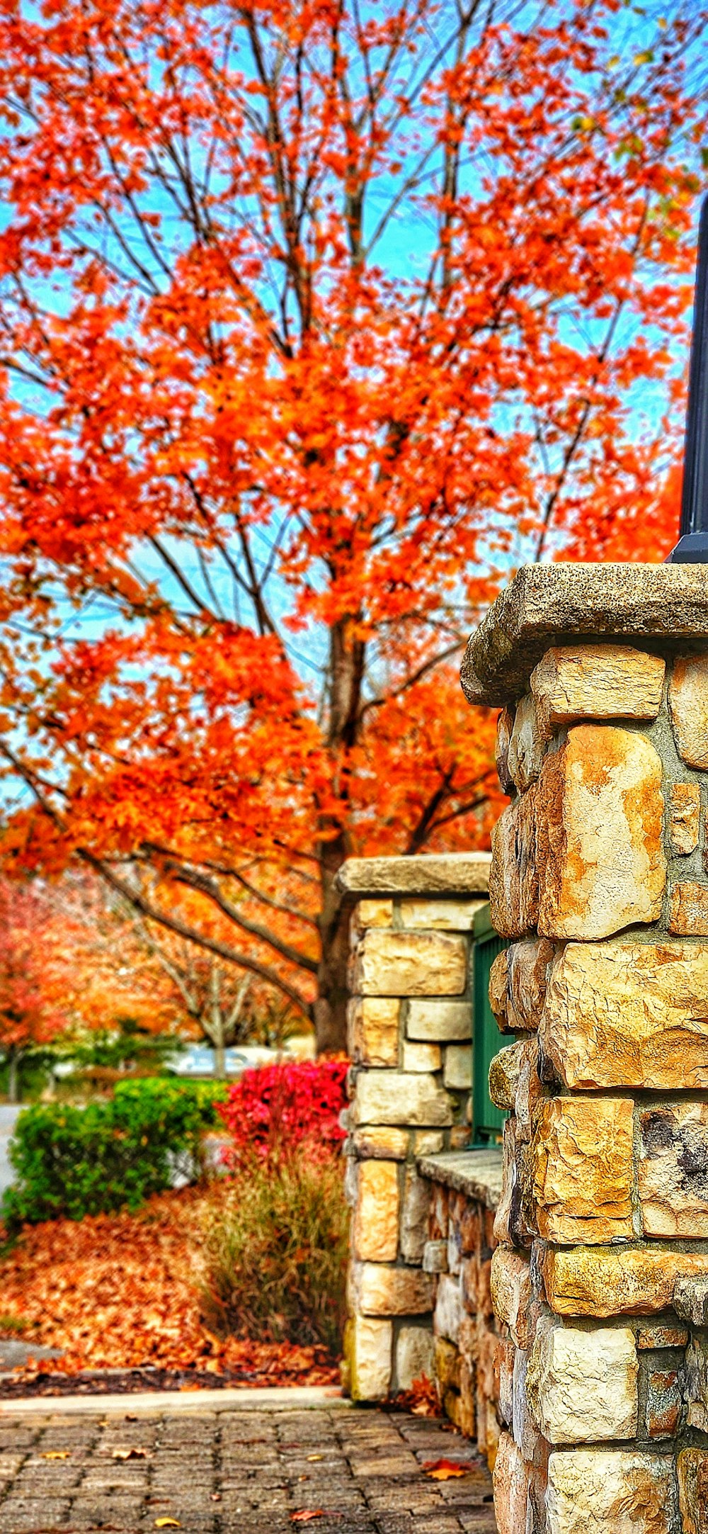 a fire hydrant sitting on the side of a stone wall