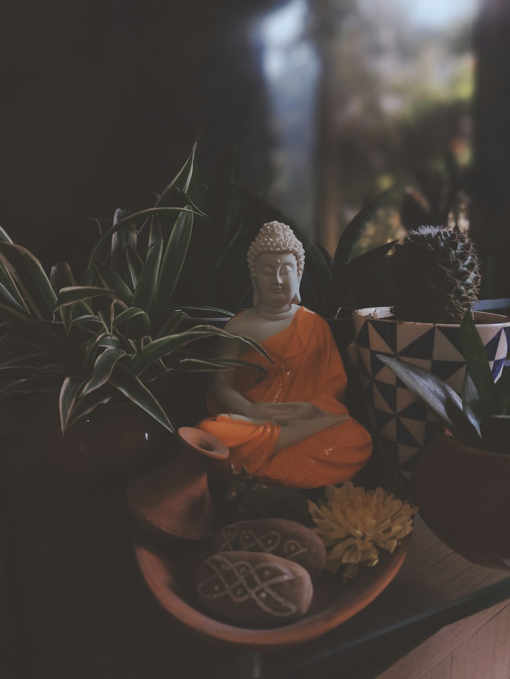 a buddha statue sitting on top of a wooden table