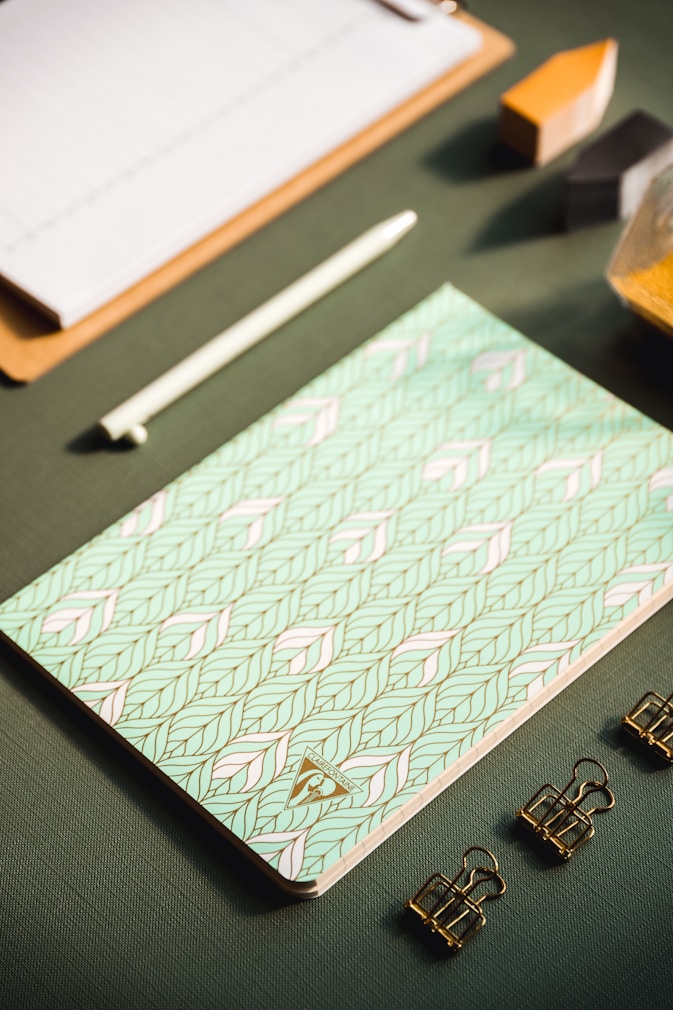A vibrant flat lay of personalized stationery items including a planner, notebooks, and custom tote bags featuring colorful designs.