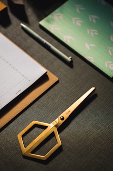 Close-up of colorful stationery items arranged neatly on a wooden desk.