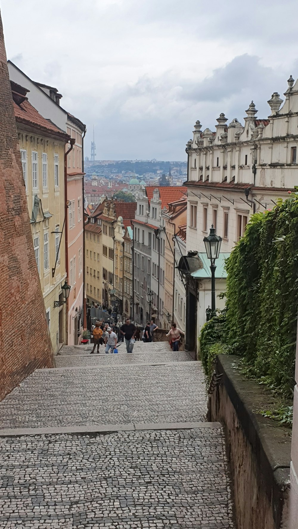 a cobblestone street with people walking down it