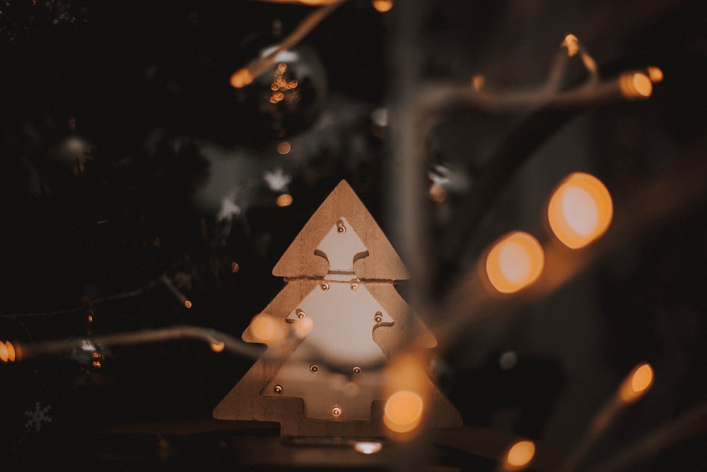 Un árbol de Navidad de madera con luces a su alrededor