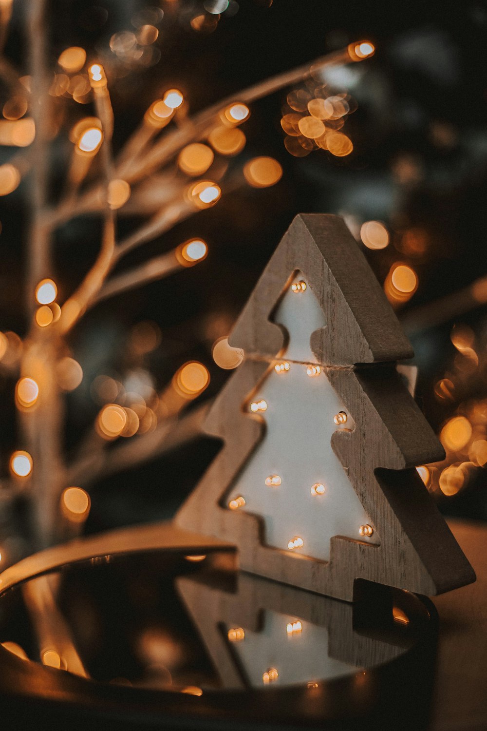 a wooden christmas tree with lights around it