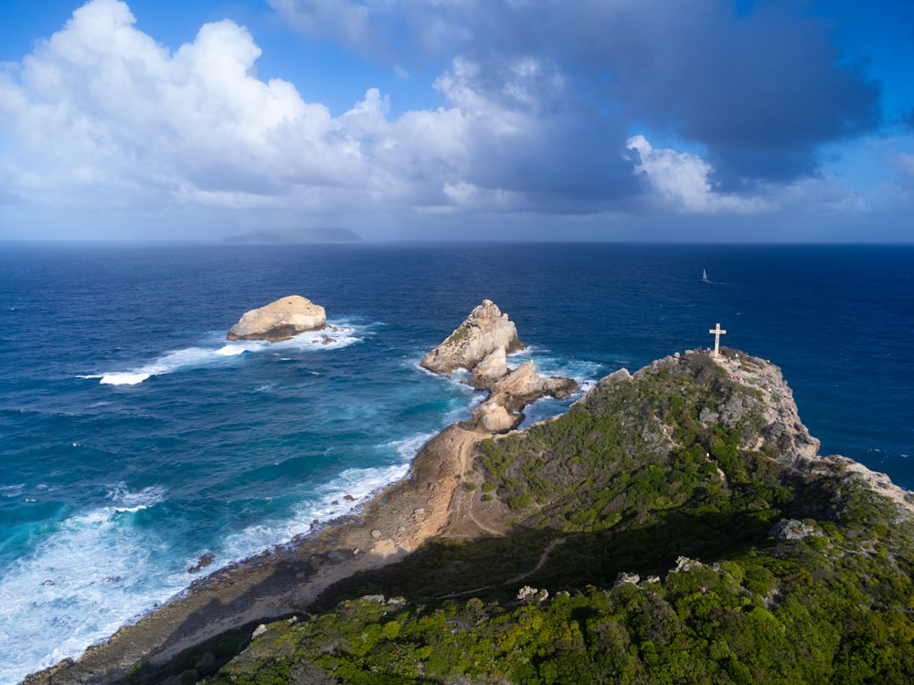 a cross on top of a mountain overlooking the ocean