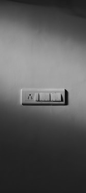 Close-up photo of a sleek silver metallic premium switch and socket on a clean ivory background.