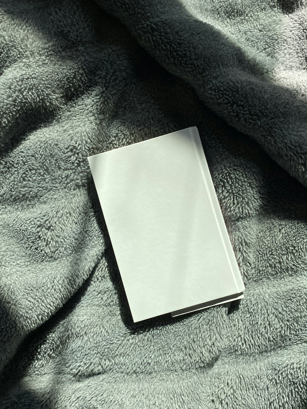 a book is laying on a gray blanket
