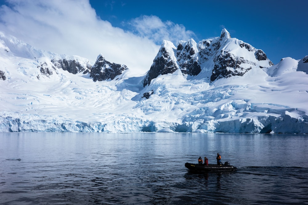 a group of people in a boat in front of a mountain