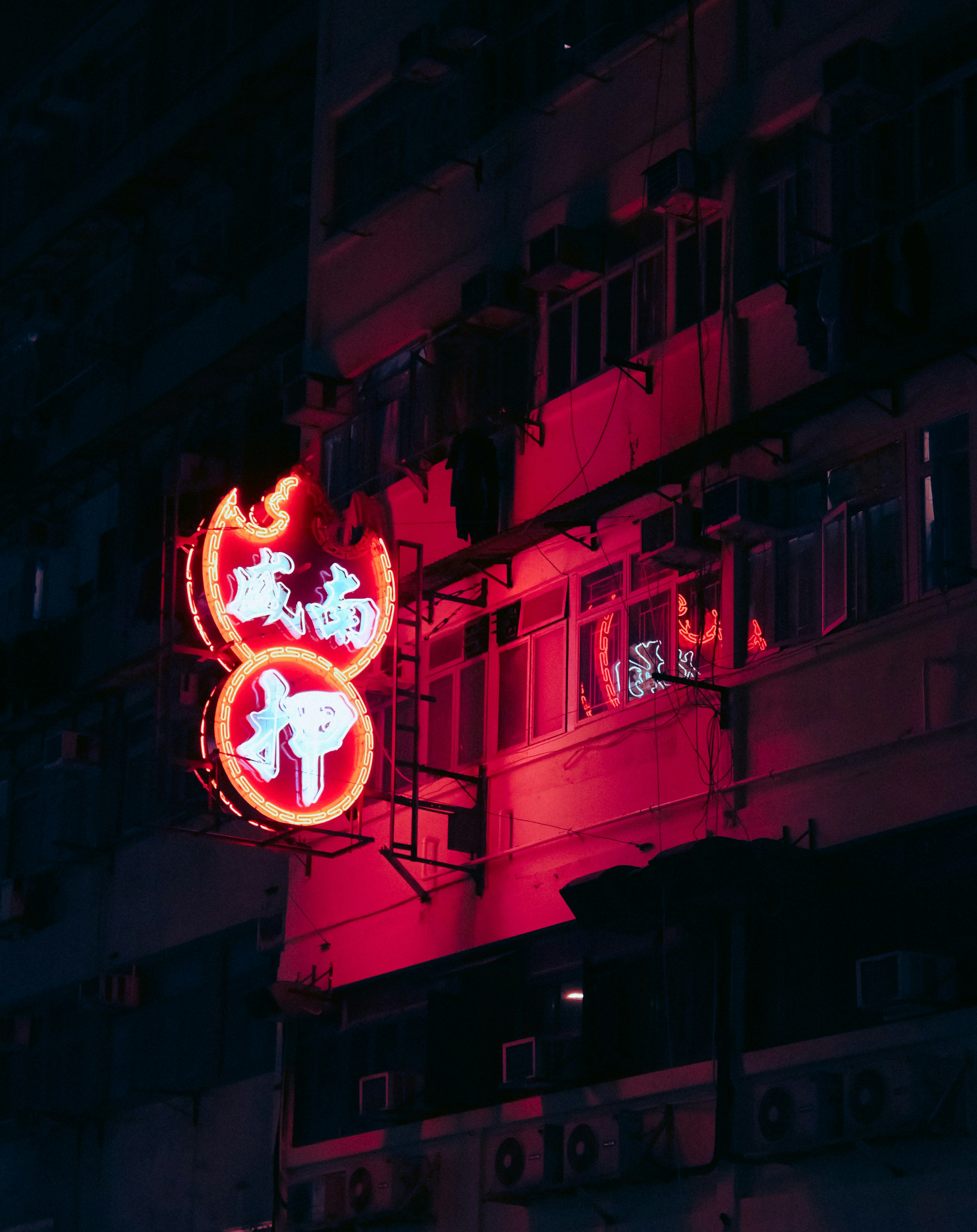 A building with a neon sign on the side of it photo – Free Neon light ...