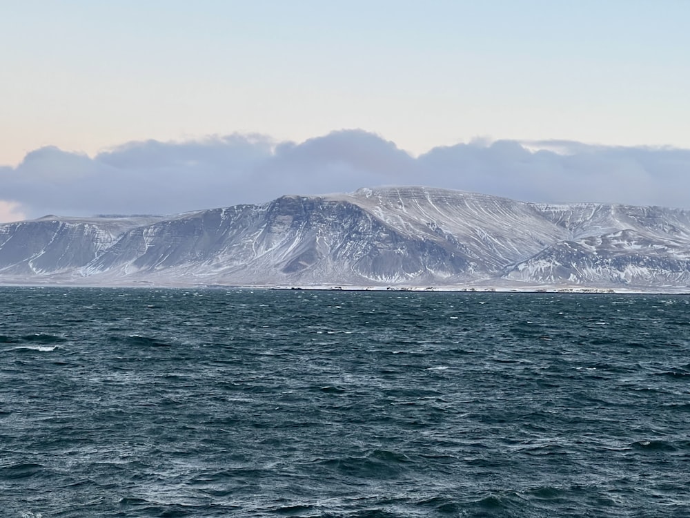 a large body of water with mountains in the background