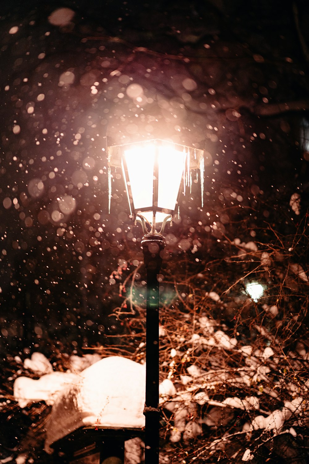 a street light in the snow at night