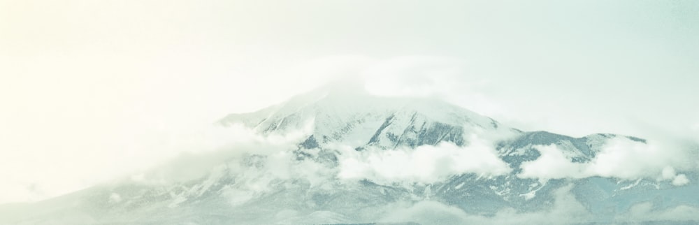 a large mountain covered in clouds in the distance