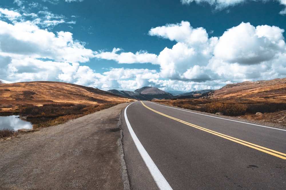 an empty road with mountains in the background