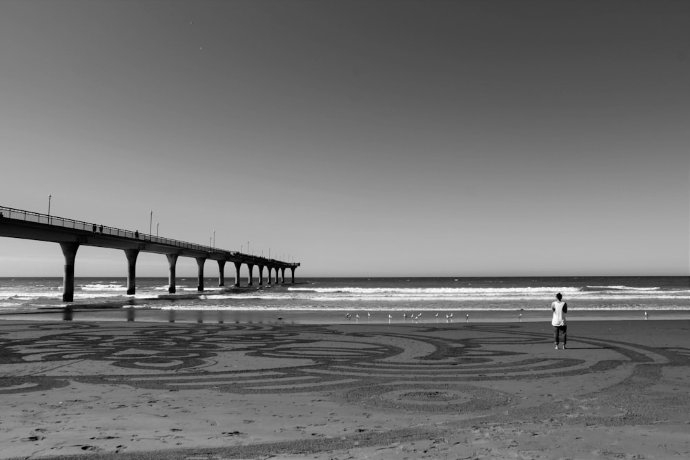 a man standing on top of a beach next to the ocean