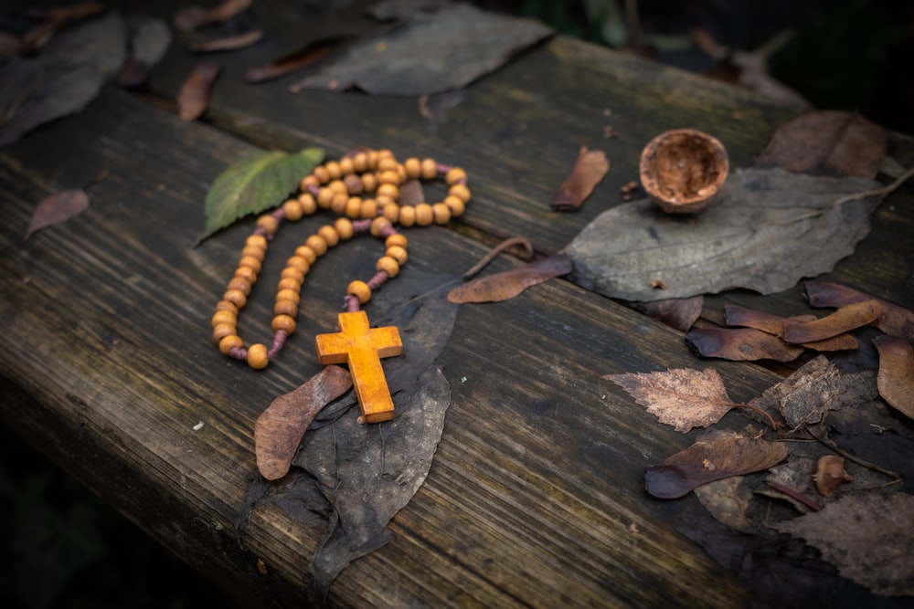 a rosary and a wooden cross on a wooden table