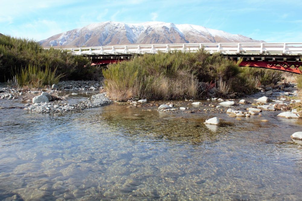 a bridge over a river with a mountain in the background
