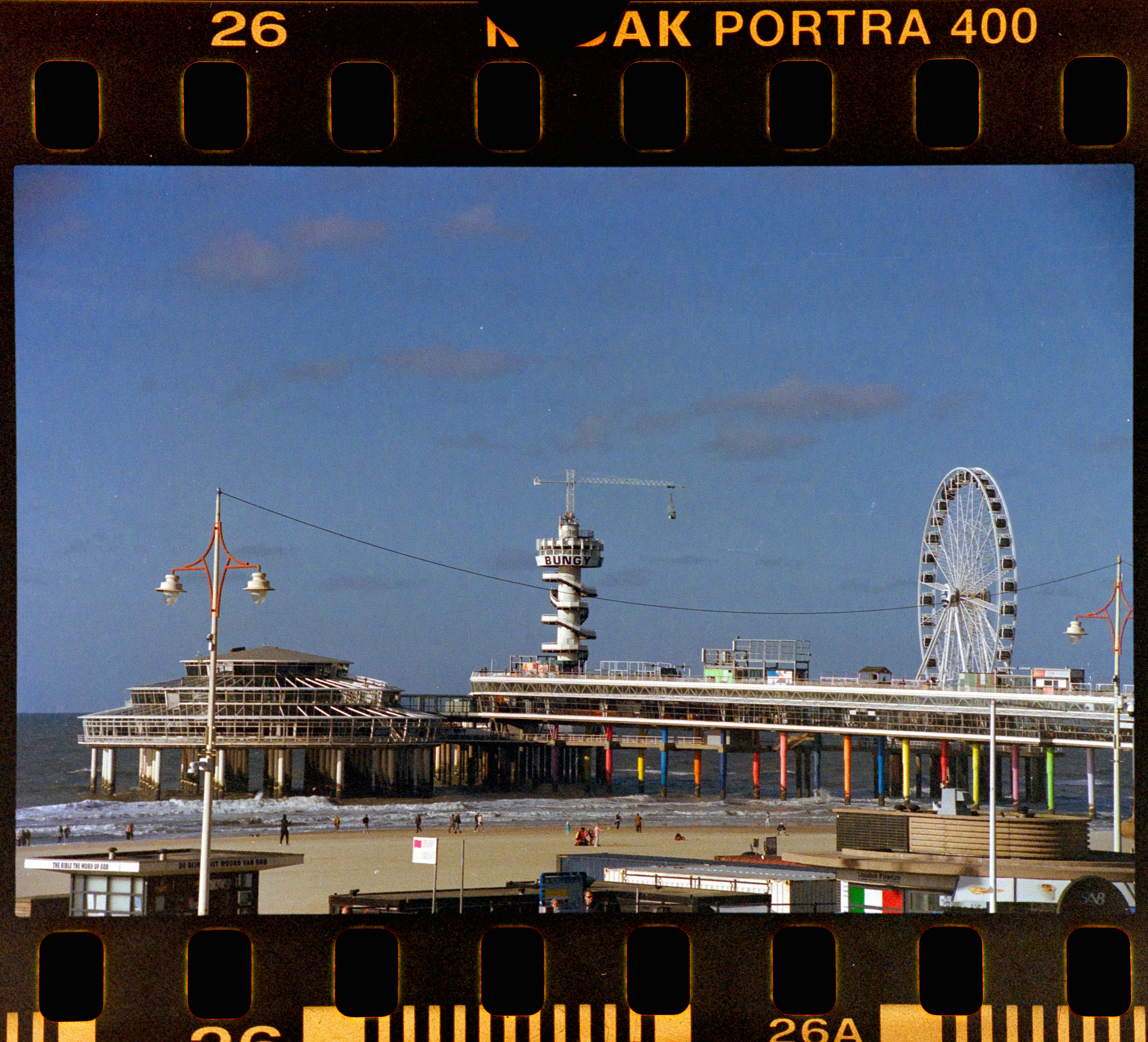 a ferris wheel sitting on top of a pier next to the ocean