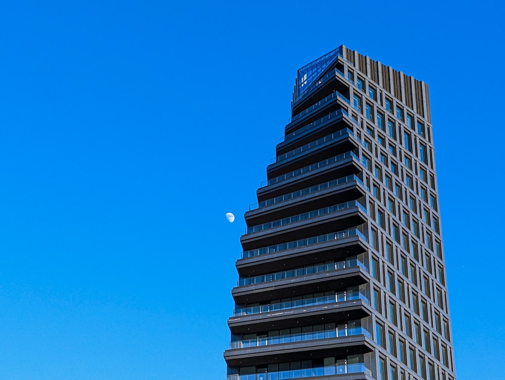 a very tall building with a moon in the sky