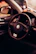 A close-up view of a car interior featuring a Volkswagen steering wheel. The dashboard and part of the driver's side door are visible, with a warm, ambient lighting casting a cozy feel. A golf-themed decorative item is placed on the dashboard.