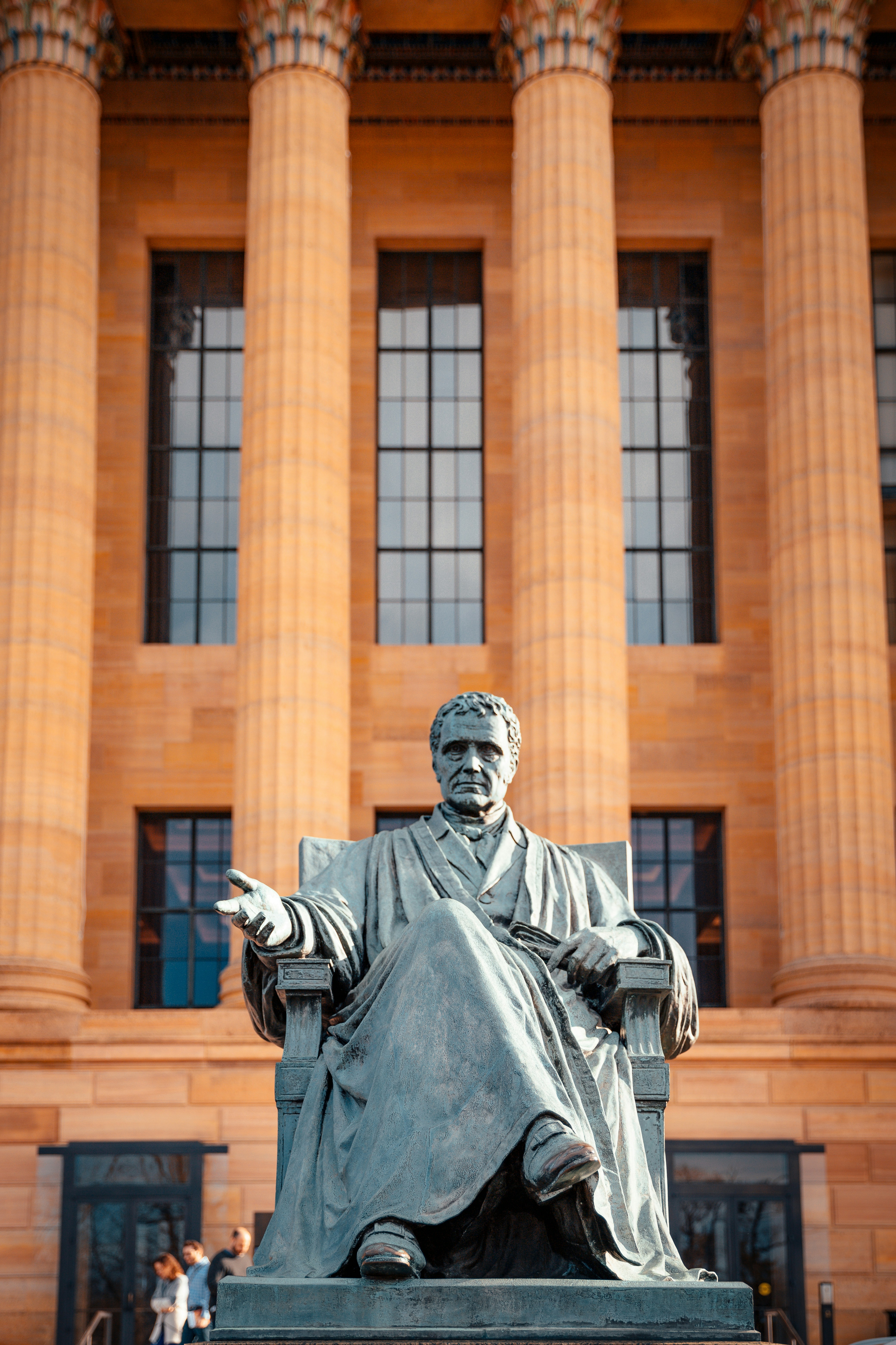 a statue of a man sitting in front of a building