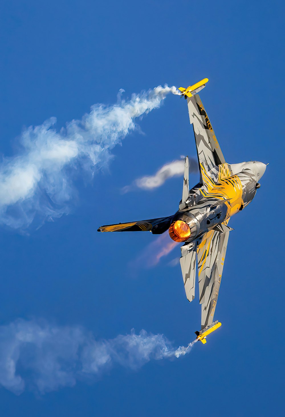 a fighter jet flying through a blue sky