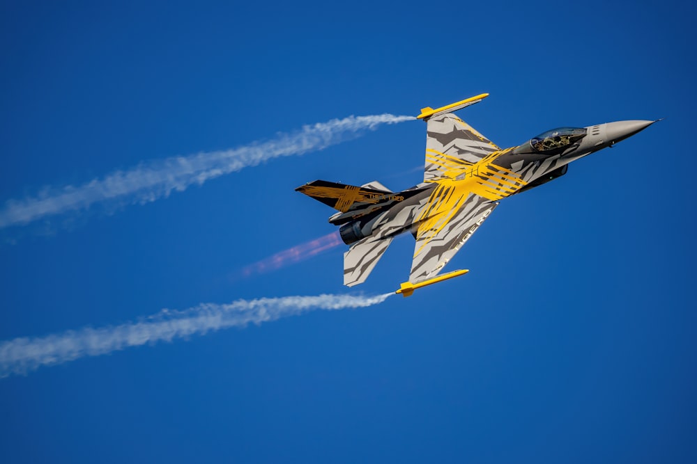 a fighter jet flying through a blue sky