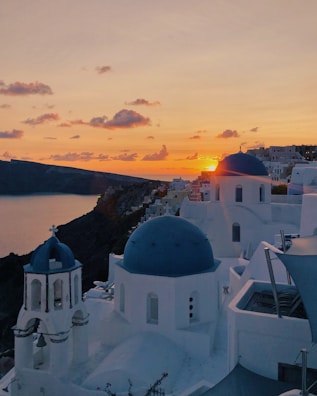 A serene sunset over Santorini’s whitewashed buildings and blue domes.