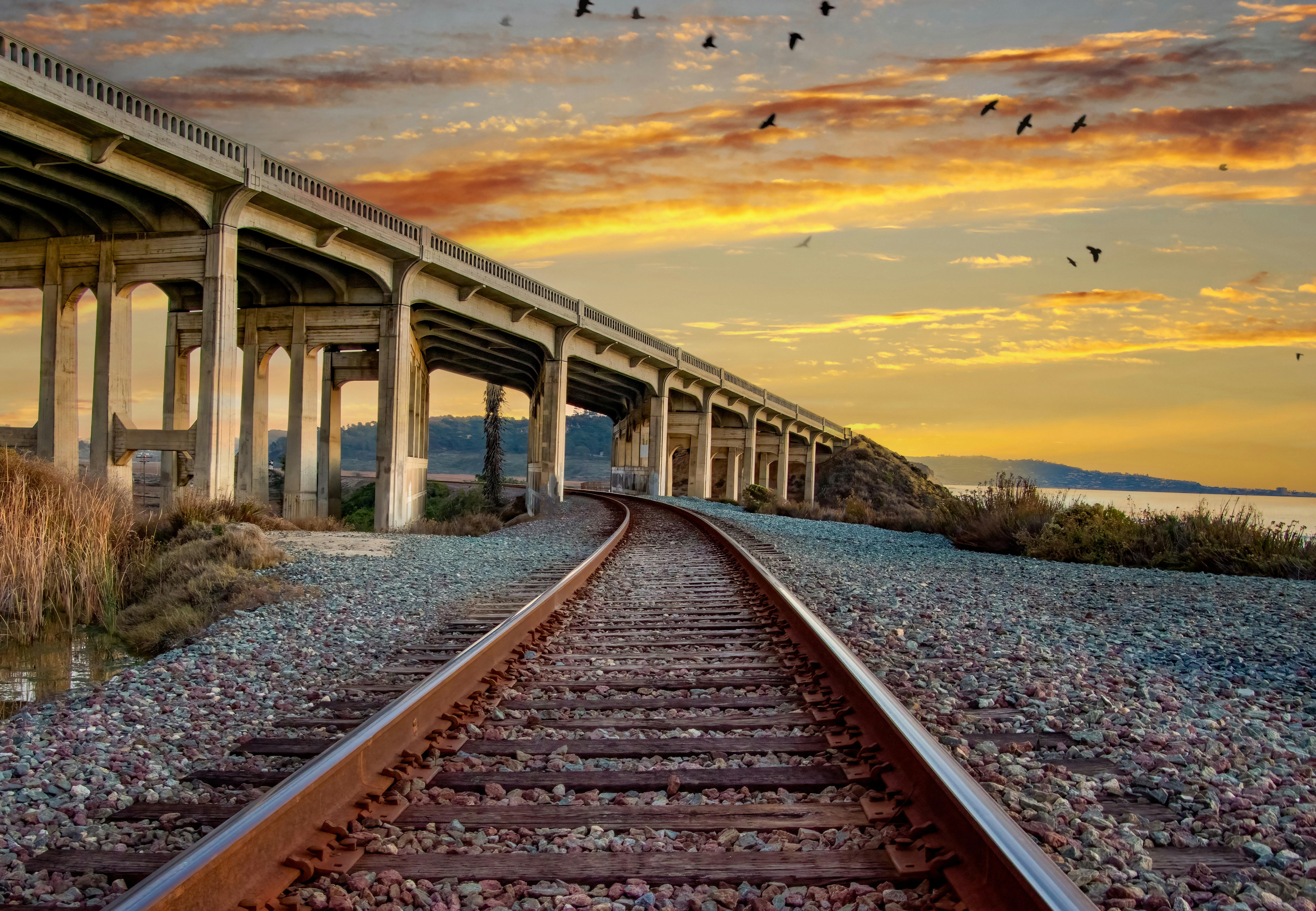 a train track with a bridge in the background