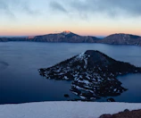 A serene view of Zugersee lake at sunset with mountains in the background
