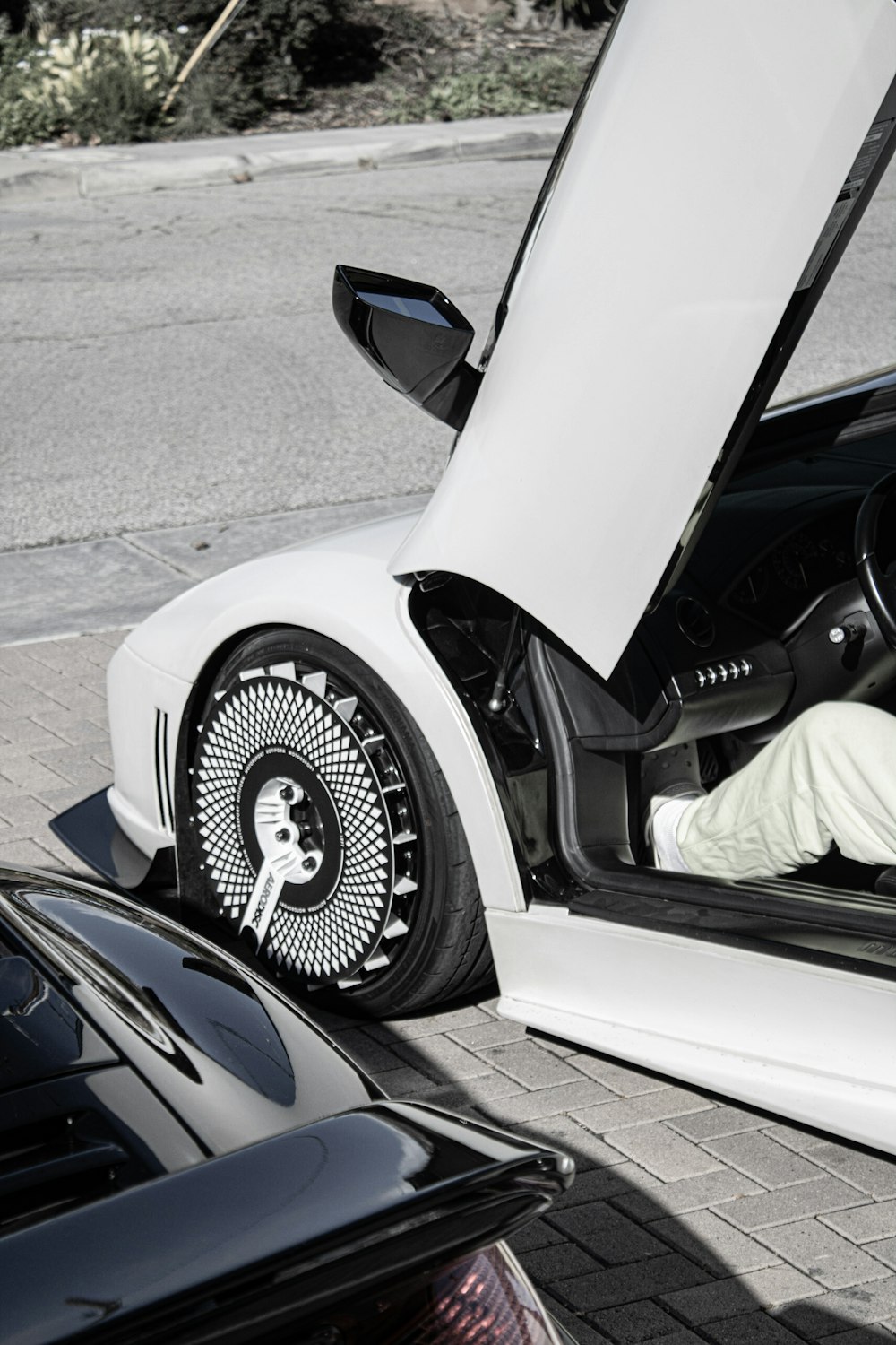 a man sitting inside of a white sports car
