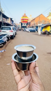 A steaming cup of rich South Indian filter coffee in a traditional stainless steel tumbler and davara.