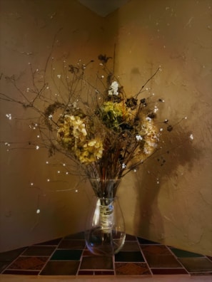 A serene corner featuring a handcrafted vase and dried florals in muted, earthy hues.