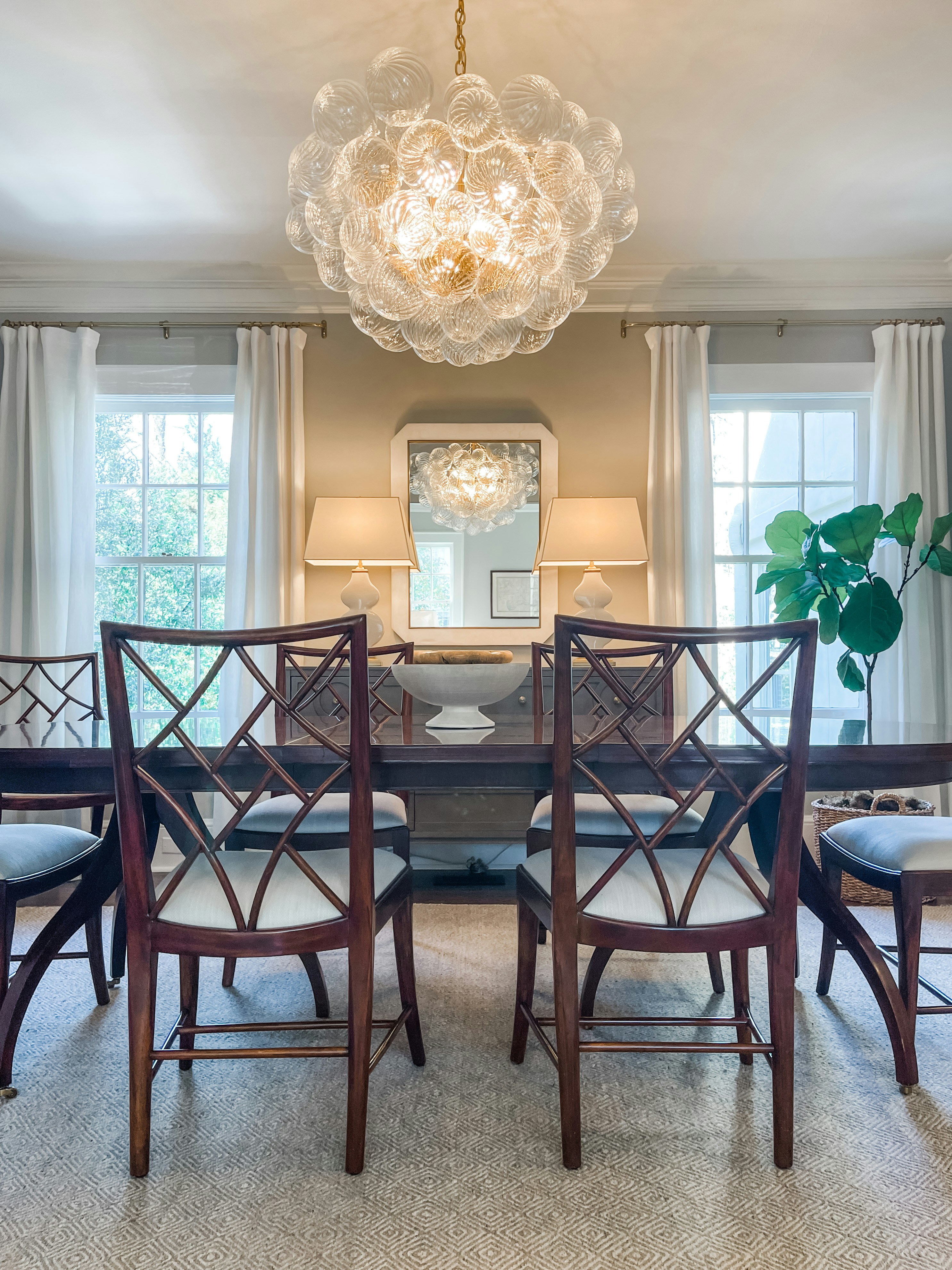 Elegant dining room with statement chandelier, dark wood table, and warm plaster walls