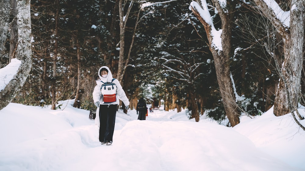 a person standing in the snow in front of some trees