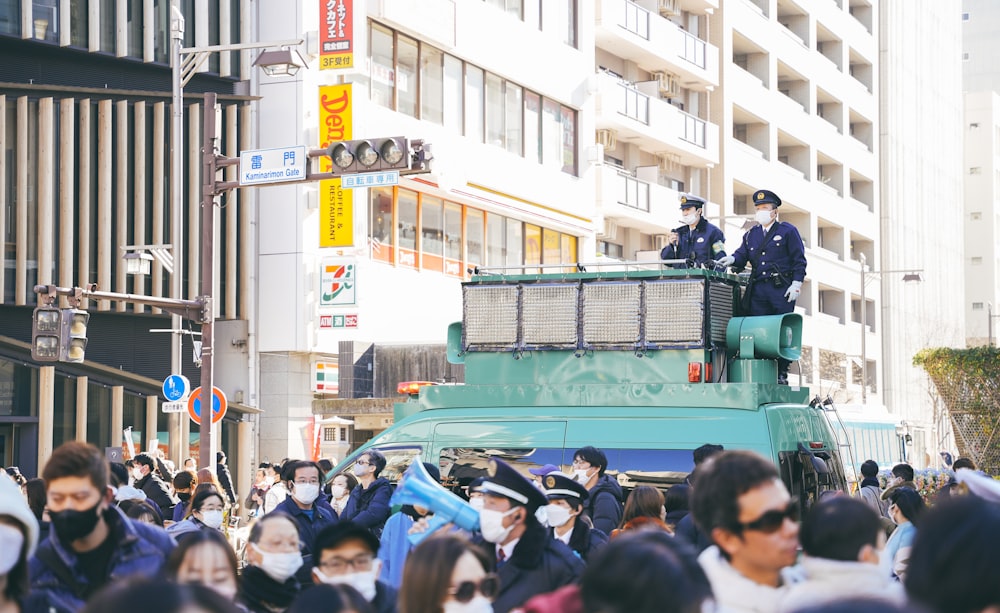 two police officers standing on top of a green vehicle