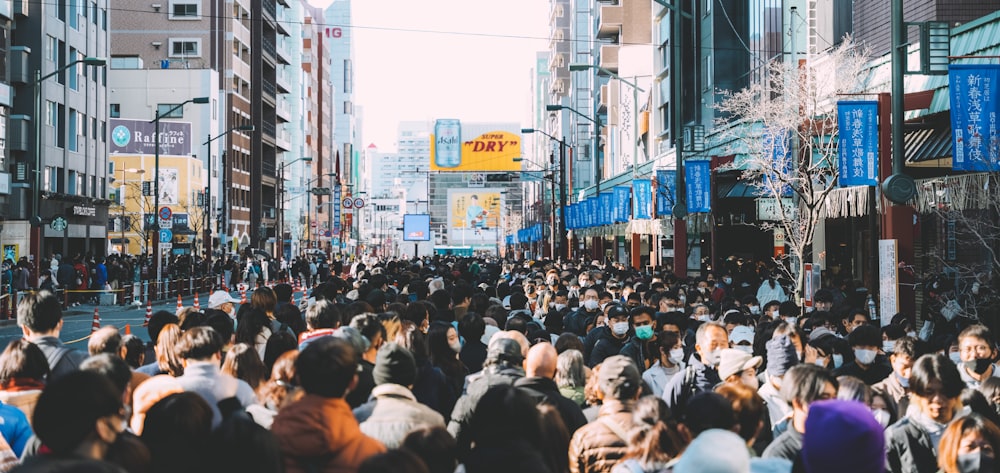 a large crowd of people walking down a city street