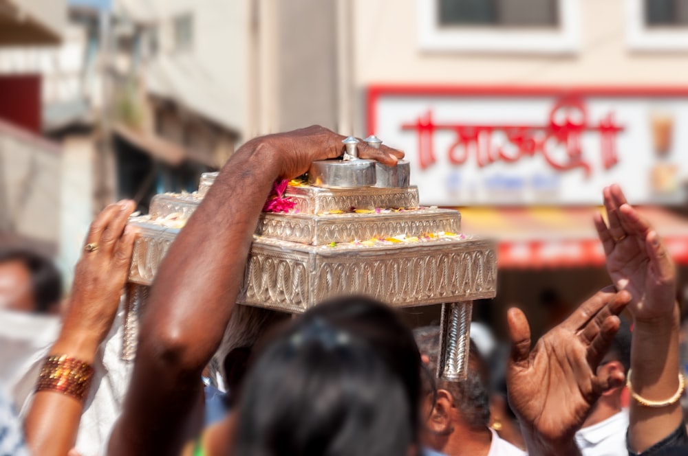 a group of people standing around a silver tray