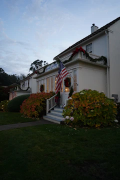 A charming colonial home in Massachusetts with a 'Sold' sign in front on a sunny day.