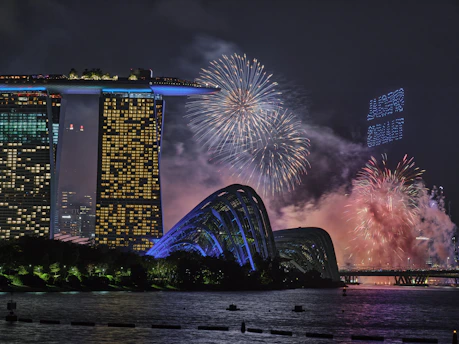 A vibrant cityscape of Singapore at dusk, showcasing Marina Bay Sands and the waterfront promenade bustling with travelers.