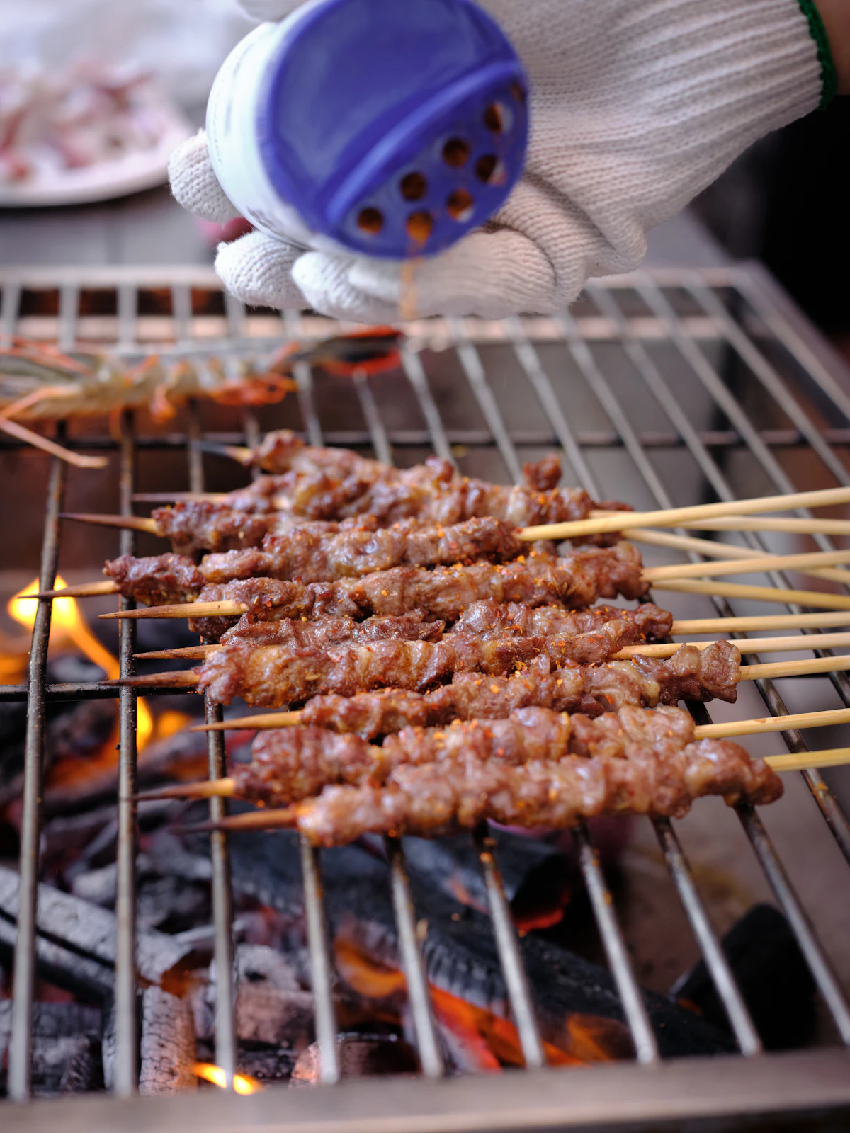 Spiced meat skewers grilled over an open BBQ flame